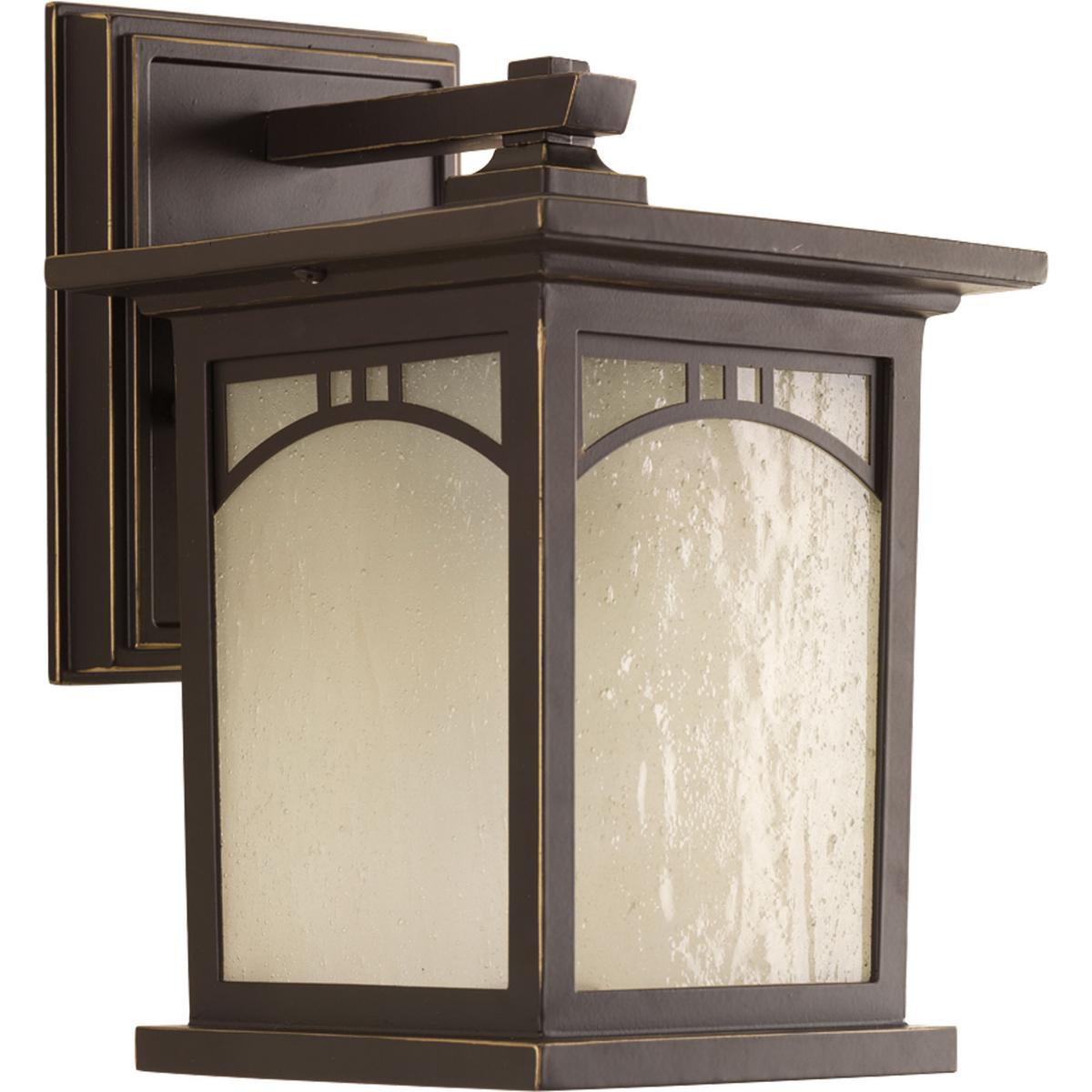 Hubbell P6052-20 Outdoor one-light small wall lantern with geometric details, umber textured art glass, and an Antique Bronze finish.  ; Antique bronze finish. ; Umber textured art glass panels. ; Geometric details.